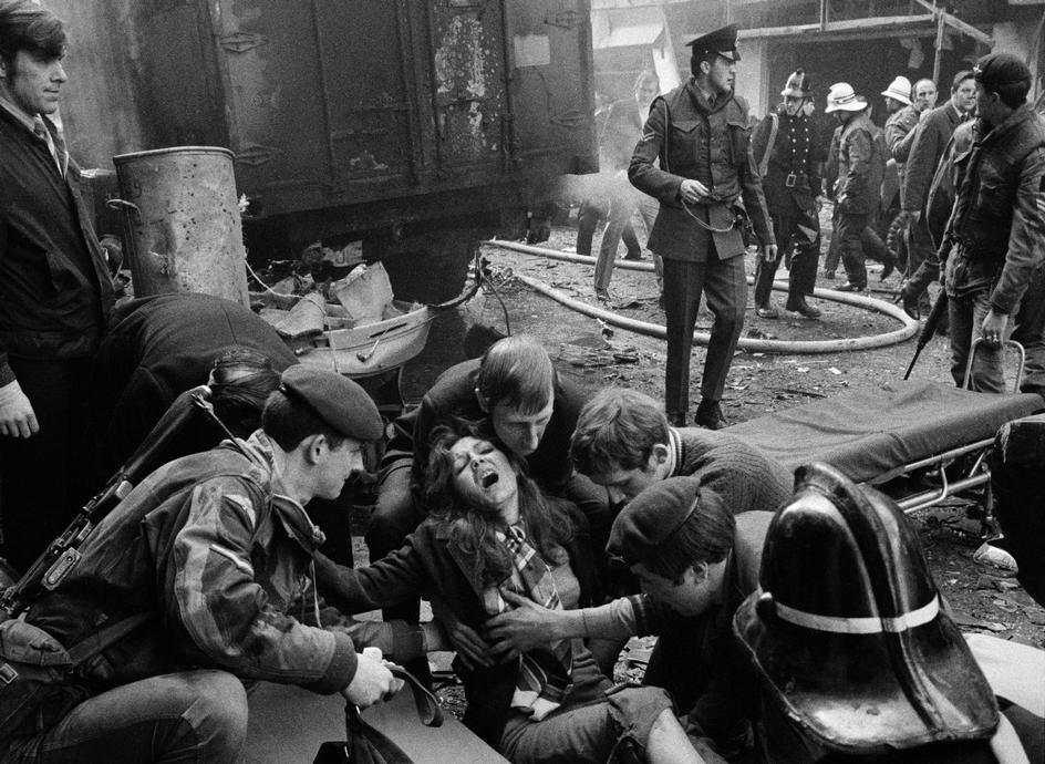 زنی که در بمب‌گذاری ارتش آزاد ایرلند در مرکز شهر آسیب دیده، تحت کمک‌های اولیه قرار گرفته است. بلفاست، ایرلند شمالی.