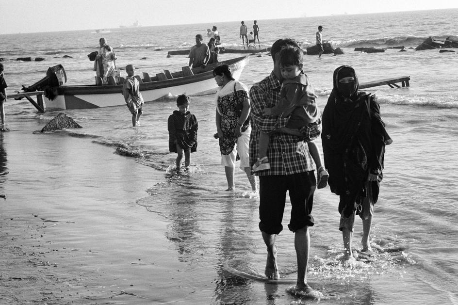 ساحل‌گردی به شیوه بنگلادشی. یک زن باحجاب و خانواده‌اش از قدم‌زدن در ساحل لذت می‌برند. چیتاگونگ، بنگلادش.